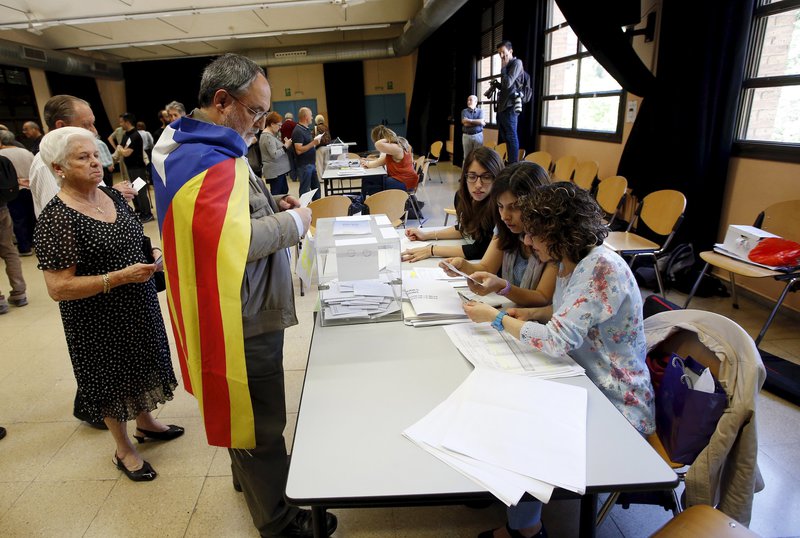 A man, wearing a "Estelada" (Catalan separatist flag) casts his vote during municipal elections in Barcelona